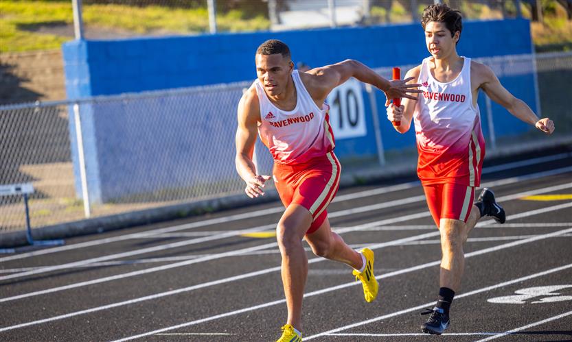 A student hands off a baton during a relay race